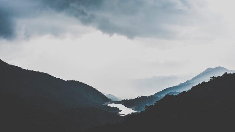 silhouette of mountains under white sky