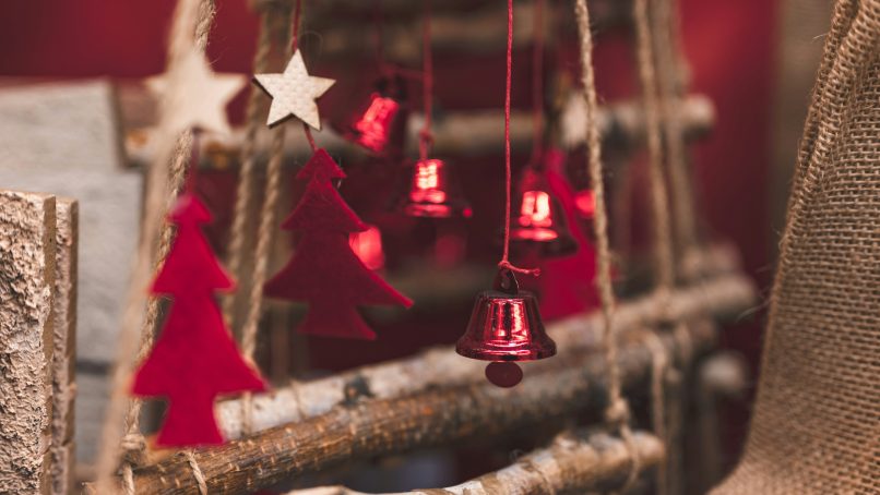 red and silver bell hanging on brown tree branch