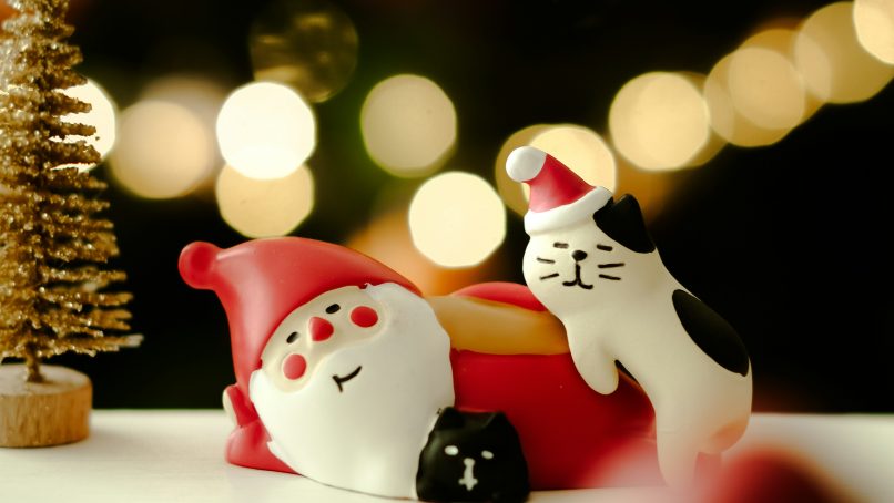 A close up of a toy car with a christmas tree in the background
