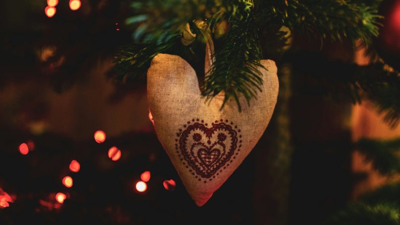 Heart-shaped ornament hanging on a christmas tree.