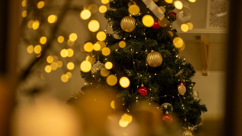 A christmas tree with lights in the background