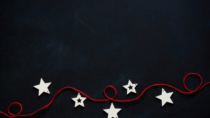 white stars cutout on black surface with red string