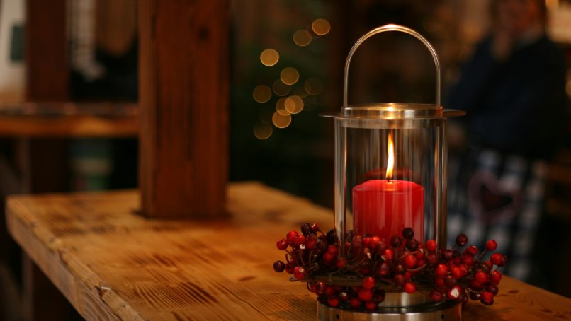 red lighted candle on brown wooden frame