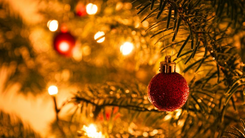 a red ornament hanging from a christmas tree