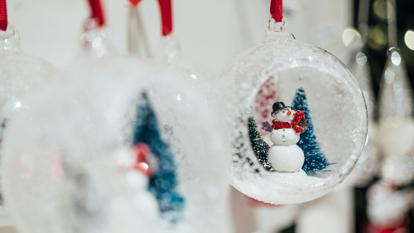 a snowman ornament hanging from a christmas tree