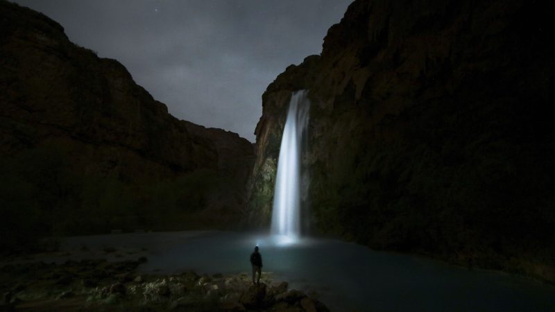 Person at night viewing a lit waterfall — Samsung Frame TV art