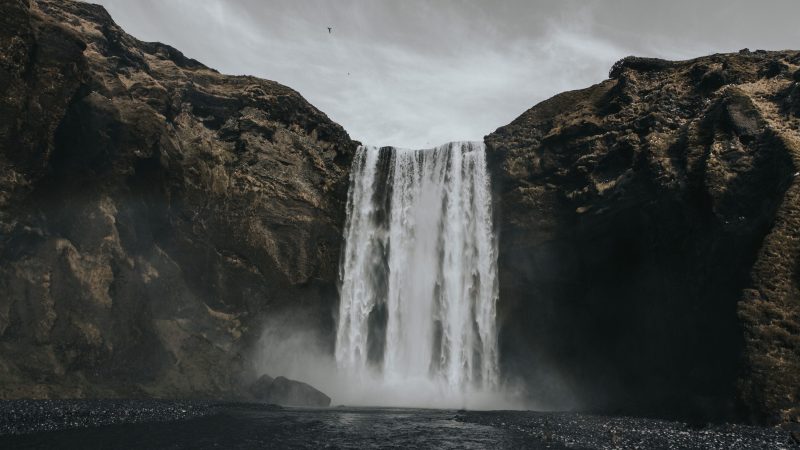 Waterfall cascading down rocky cliffs into misty pool below. — Samsung Frame TV art