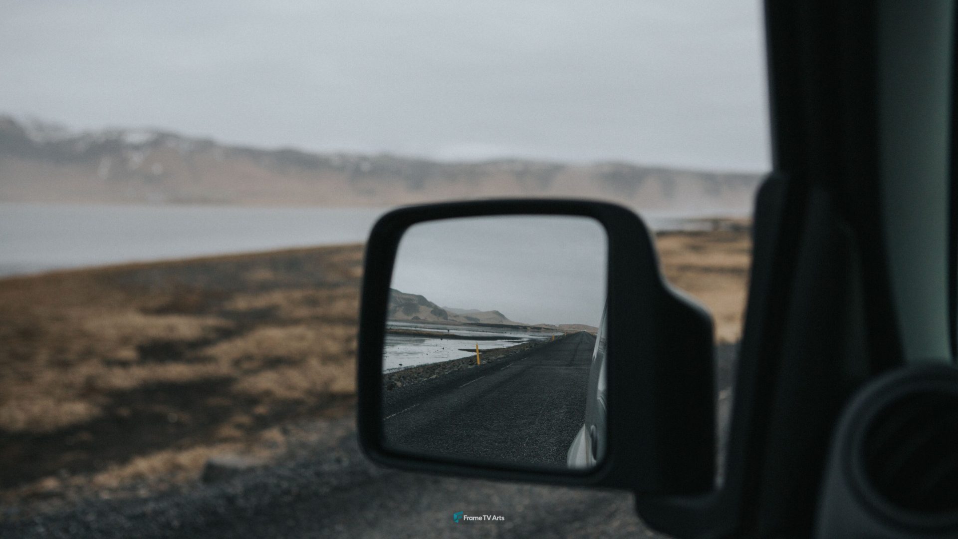 Road through barren landscape reflected in side view car mirror. — Samsung Frame TV art