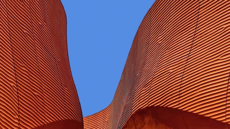 Abstract rust-colored modern building against blue sky. — Samsung Frame TV art