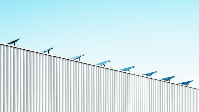 Solar panels line the edge of a corrugated building roof — Samsung Frame TV art