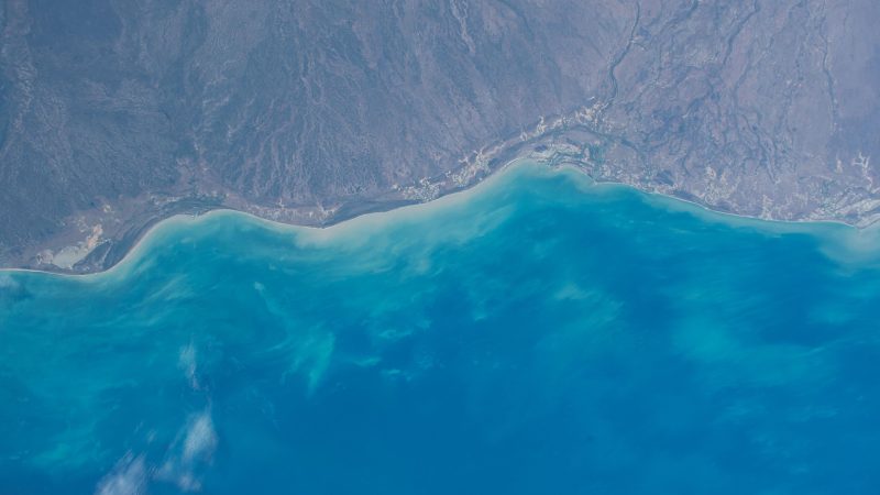 Aerial view of a coastal region with clear blue waters and land. — Samsung Frame TV art