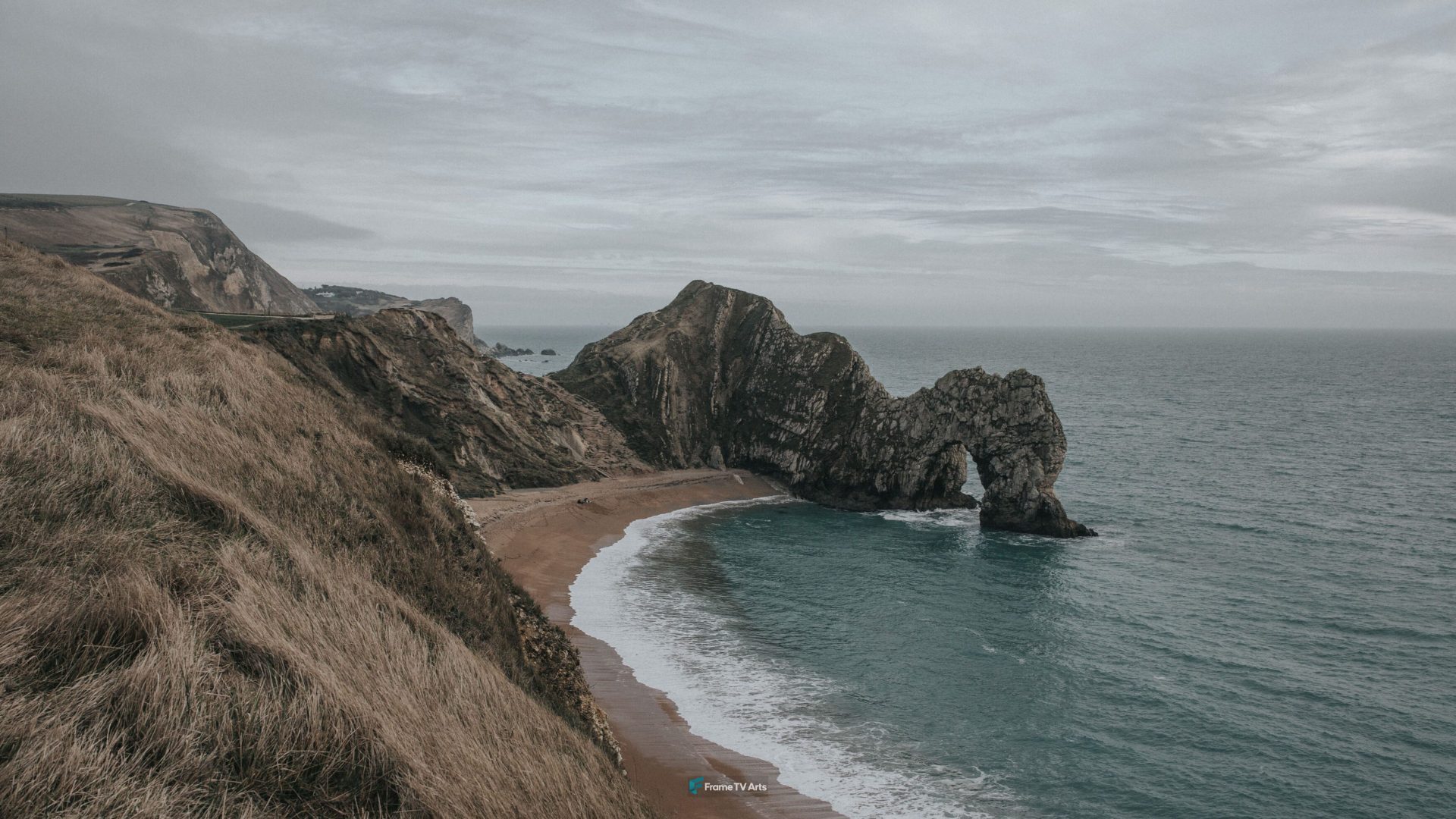 Coastal view of a stone arch in the ocean with grassy cliffs — Samsung Frame TV art
